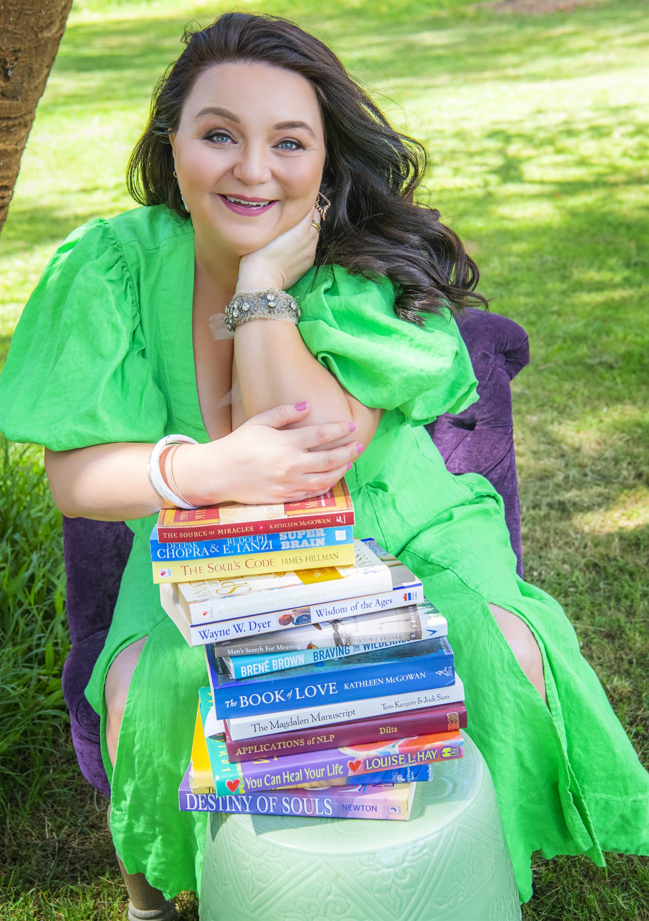 Lauren Jobson outdoors holding a stack of personal development books